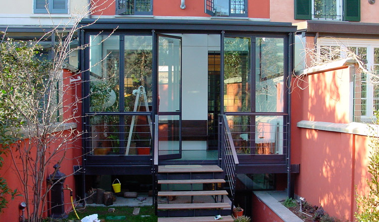 Serra Garden: Veranda in un giardino milanese caratterizzata da pavimentazione in vetro satinato Progetto Studio Vigo